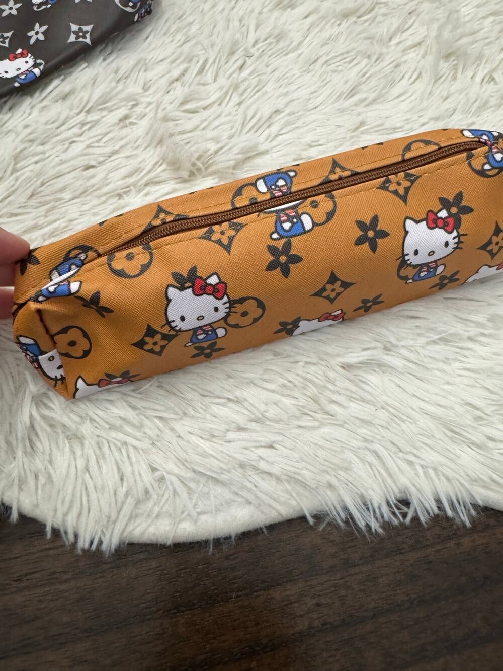 Hello Kitty pencil case with floral  monogram pattern on a mostard background